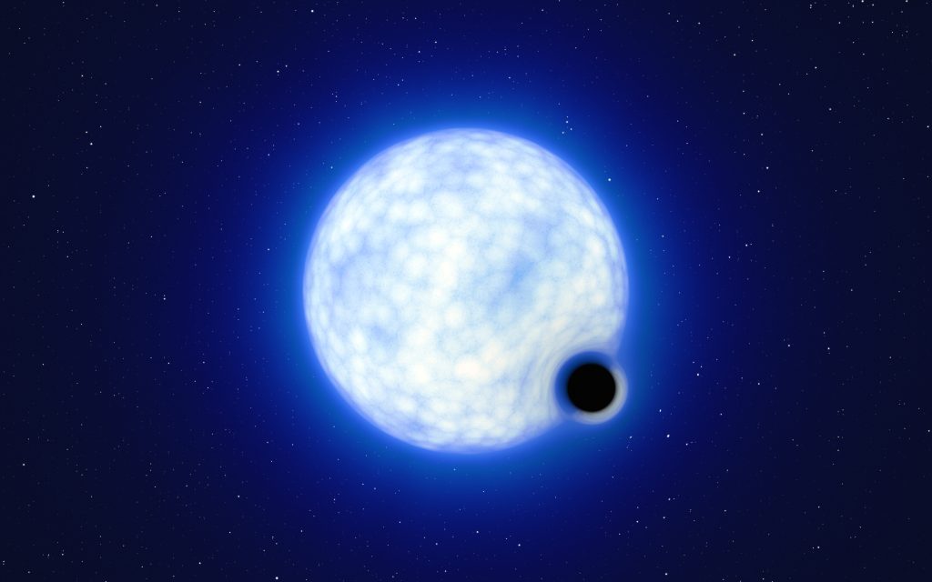 This artist’s impression shows what the binary system VFTS 243 might look like if we were observing it up close. The system, which is located in the Tarantula Nebula in the Large Magellanic Cloud, is composed of a hot, blue star with 25 times the Sun’s mass and a black hole, which is at least nine times the mass of the Sun. The sizes of the two binary components are not to scale: in reality, the blue star is about 200 000 times larger than the black hole.  Note that the 'lensing' effect around the black hole is shown for illustration purposes only, to make this dark object more noticeable in the image. The inclination of the system means that, when looking at it from Earth, we cannot observe the black hole eclipsing the star.